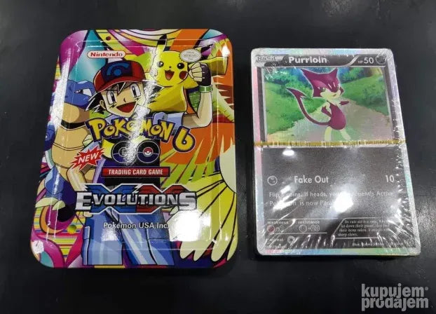 Manja metalna kutija sa Pokémon kartama, obavijena celofanom.
