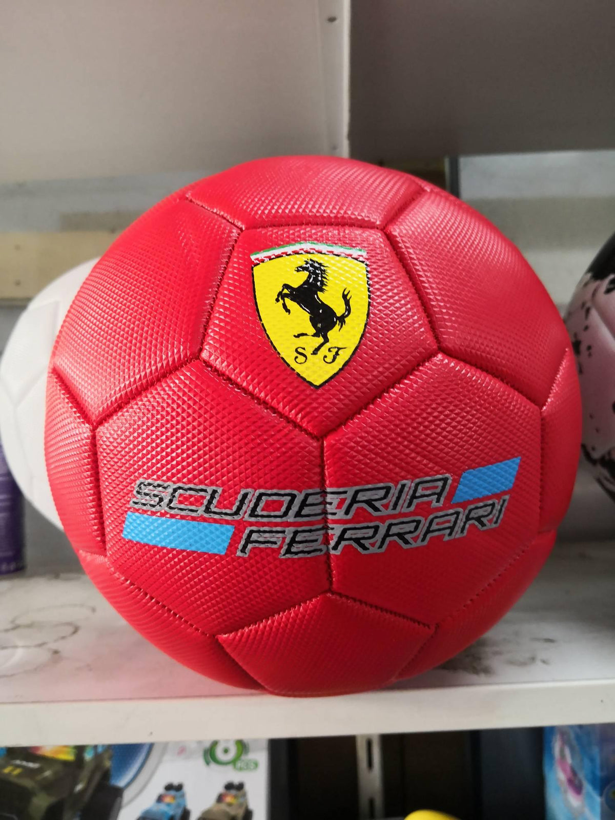 Fudbalska lopta Ferrari u crvenoj kožnoj izvedbi.