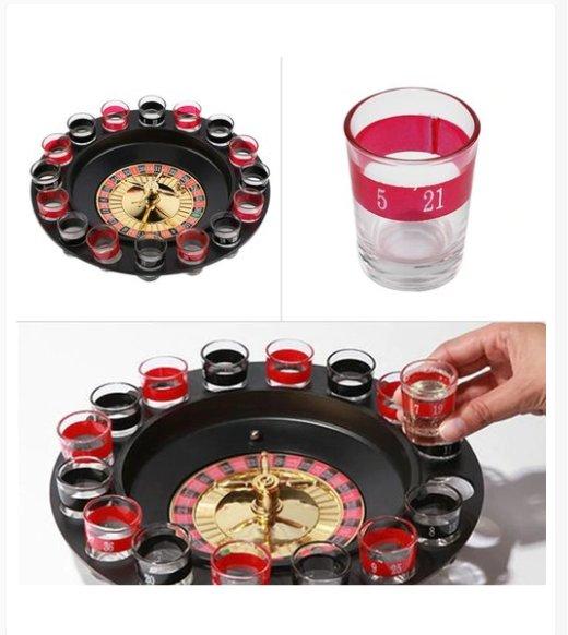 Prikaz igre ruleta za piće sa točkom, metalnim kuglicama i čašicama.