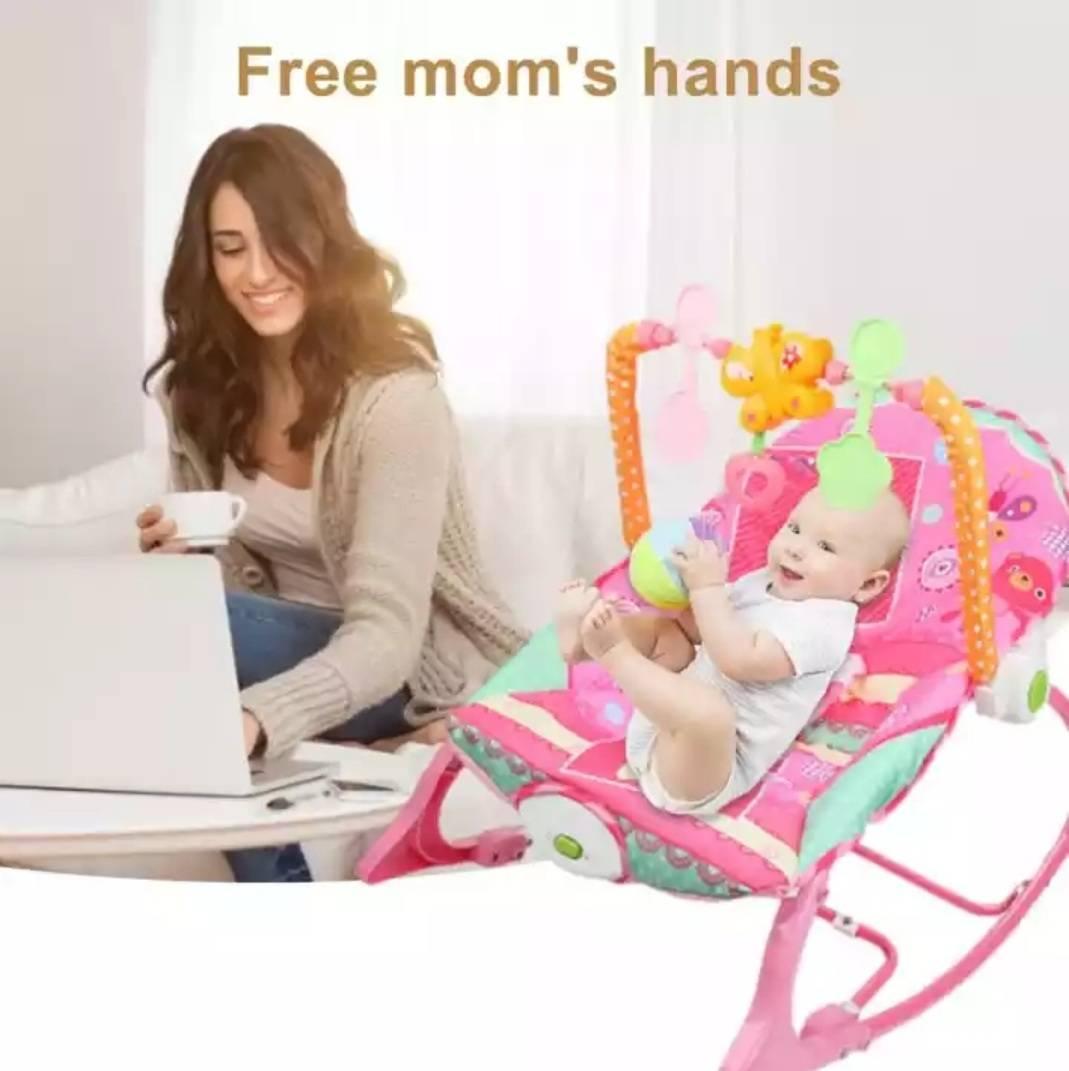 Bebi-njihalica u roze boji sa trakom za igračke.
