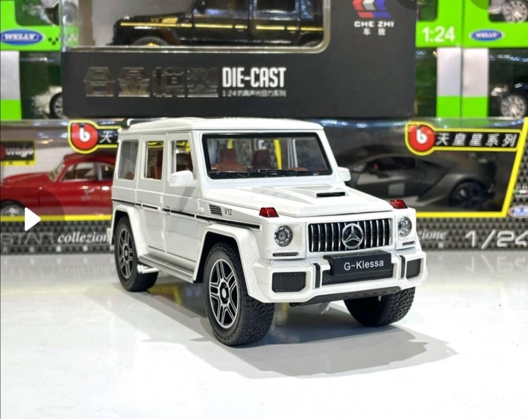 Beli model AMG G63 prikazuje metalni autić sa prepoznatljivim izgledom vozila.