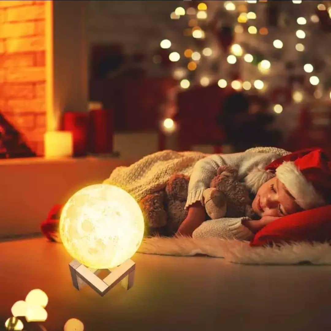 Dekorativna 3D lampa u obliku Meseca prikazana je uz drveno postolje.