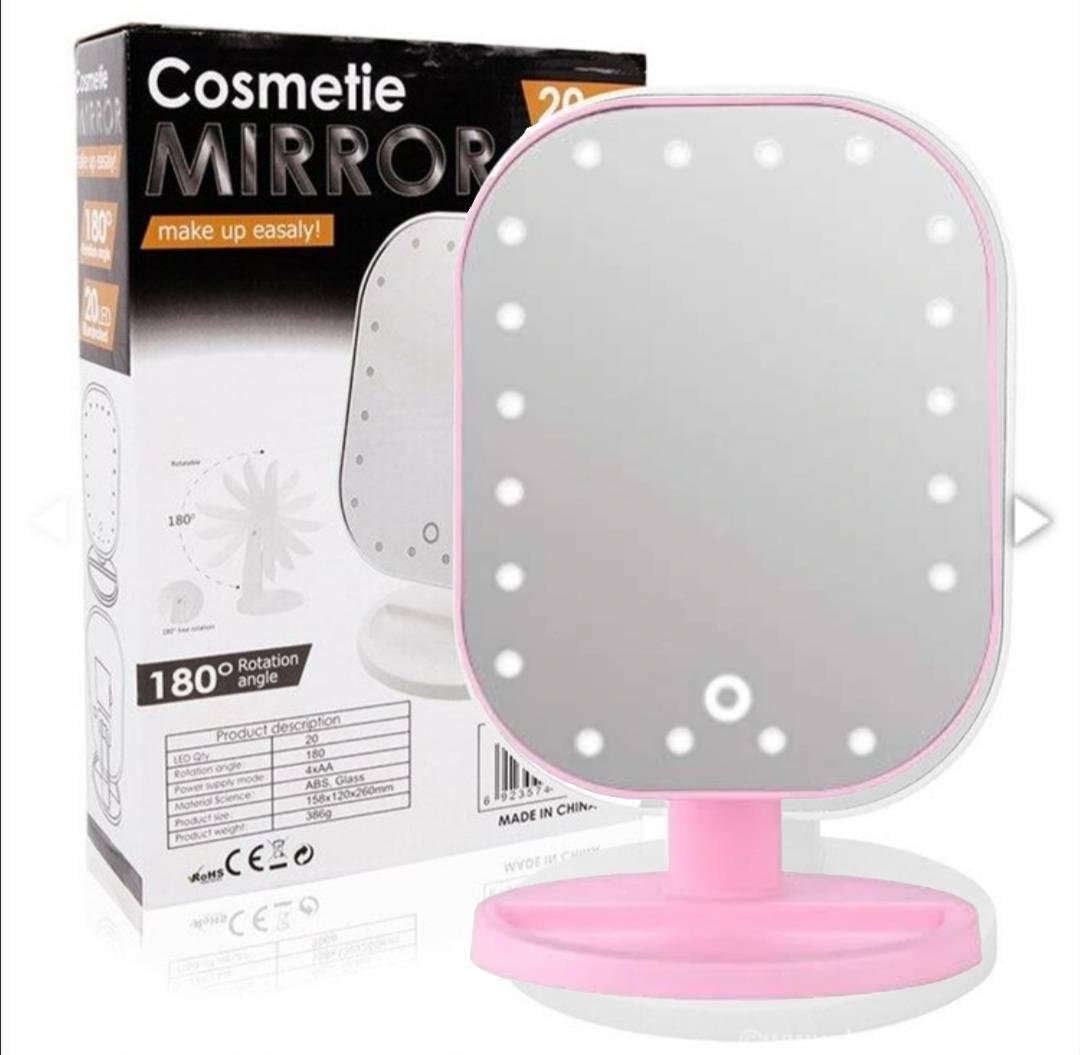 Roze ogledalo za šminkanje sa LED diodama oko površine ogledala.