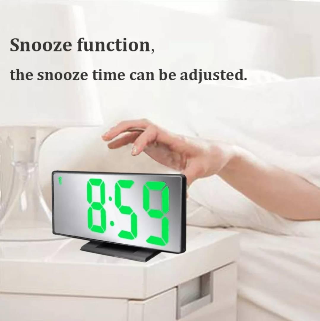Digitalni ogledalo sat sa belim oznakama na LED ekranu.