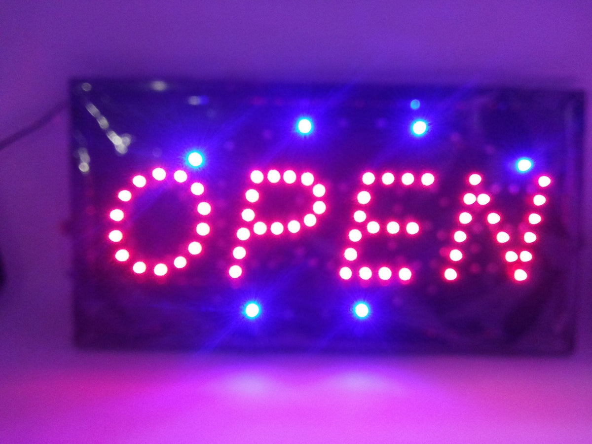 Na slici je svetleća LED reklama sa natpisom OPEN/CLOSE.