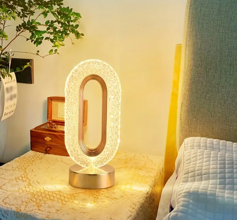 Kristalno oblikovan abažur postavljen iznad zlatne baze stone lampe.