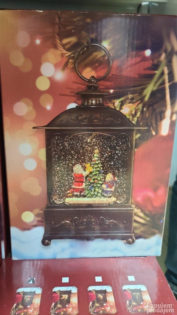 Dekorativna lampa sa novogodišnjim prizorom Deda Mraza i jelke.